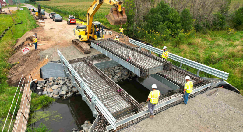 Construction workers installing a modular bridge on-site.