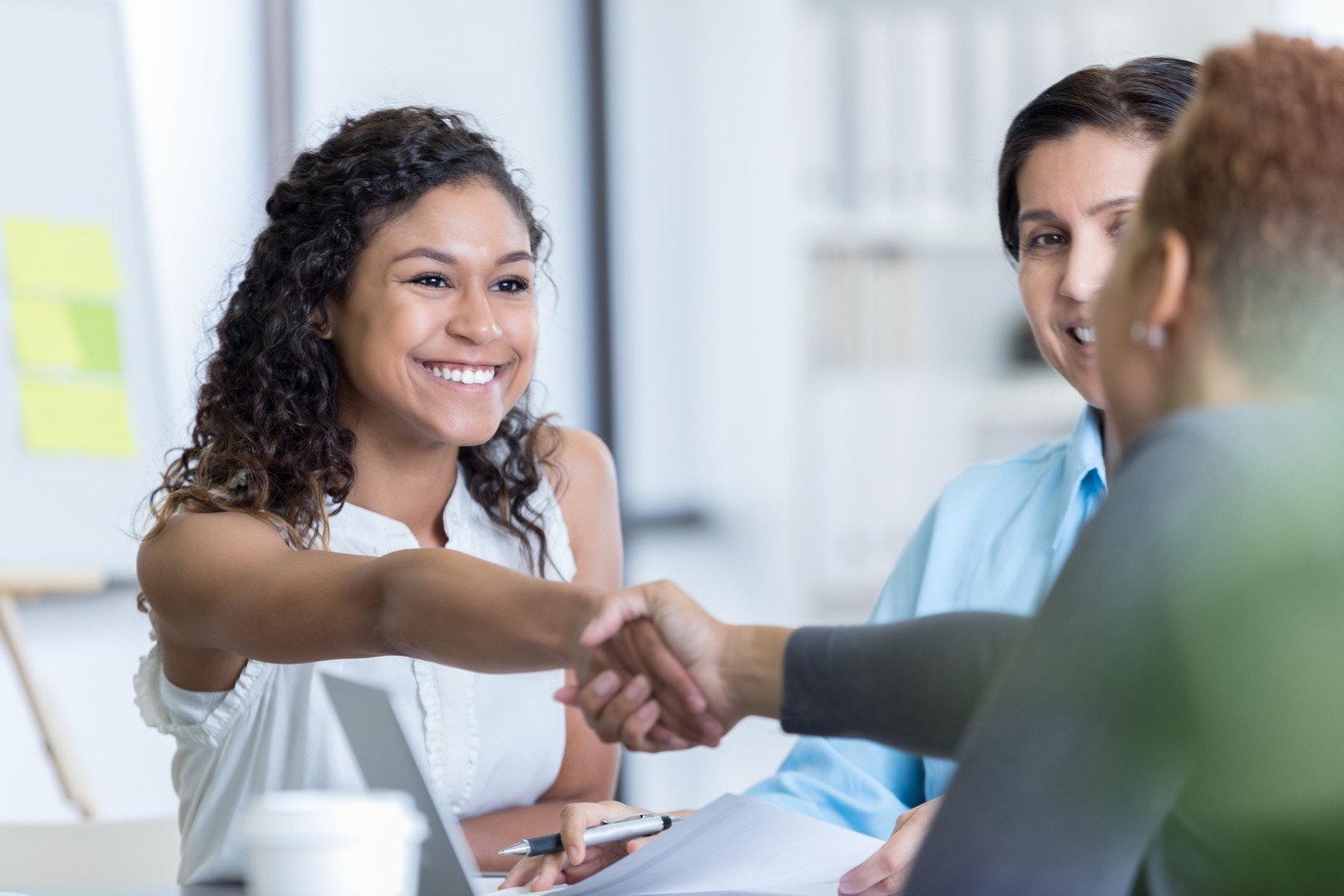 Two people shaking hands in a professional setting, representing successful partnerships.